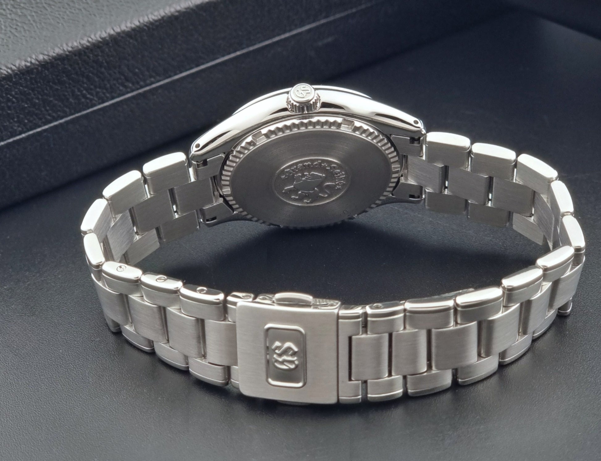 Grand Seiko SBGX005 quartz watch 9F62-0A10 with a detailed face on a dark textured surface clasp view