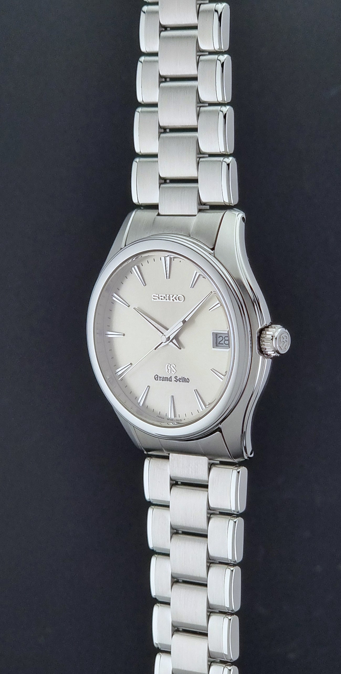 Grand Seiko SBGX005 quartz watch 9F62-0A10 with a detailed face on a dark textured surface crown profile view 
