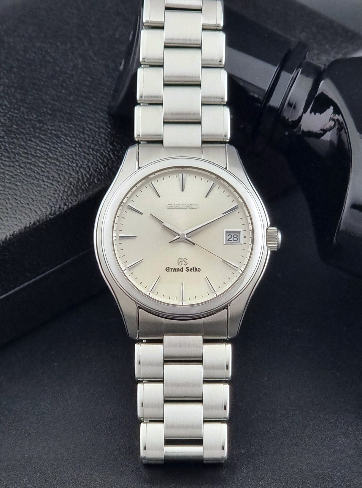 Grand Seiko SBGX005 quartz watch 9F62-0A10 with a detailed face on a dark textured surface front view