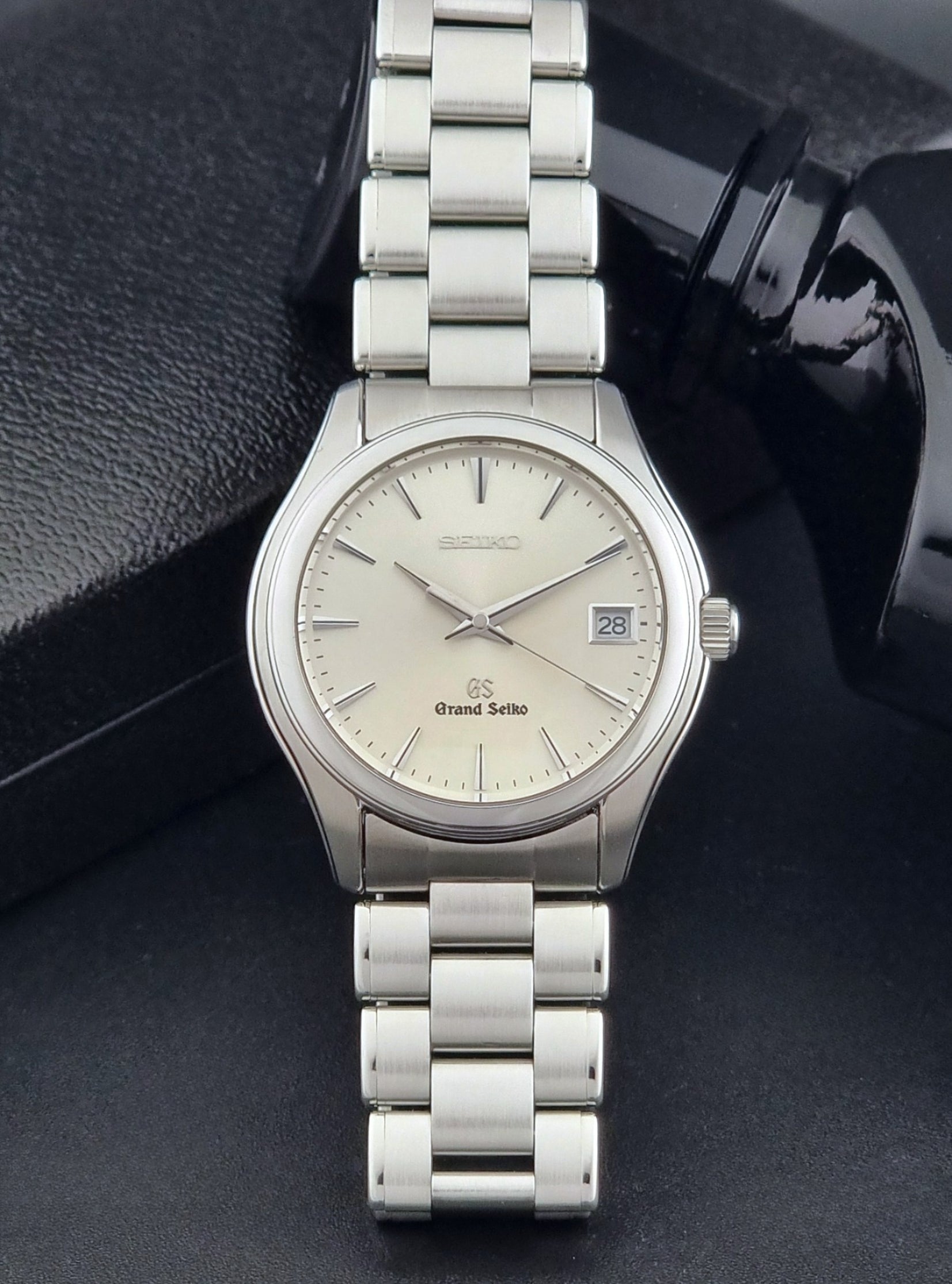 Grand Seiko SBGX005 quartz watch 9F62-0A10 with a detailed face on a dark textured surface front view