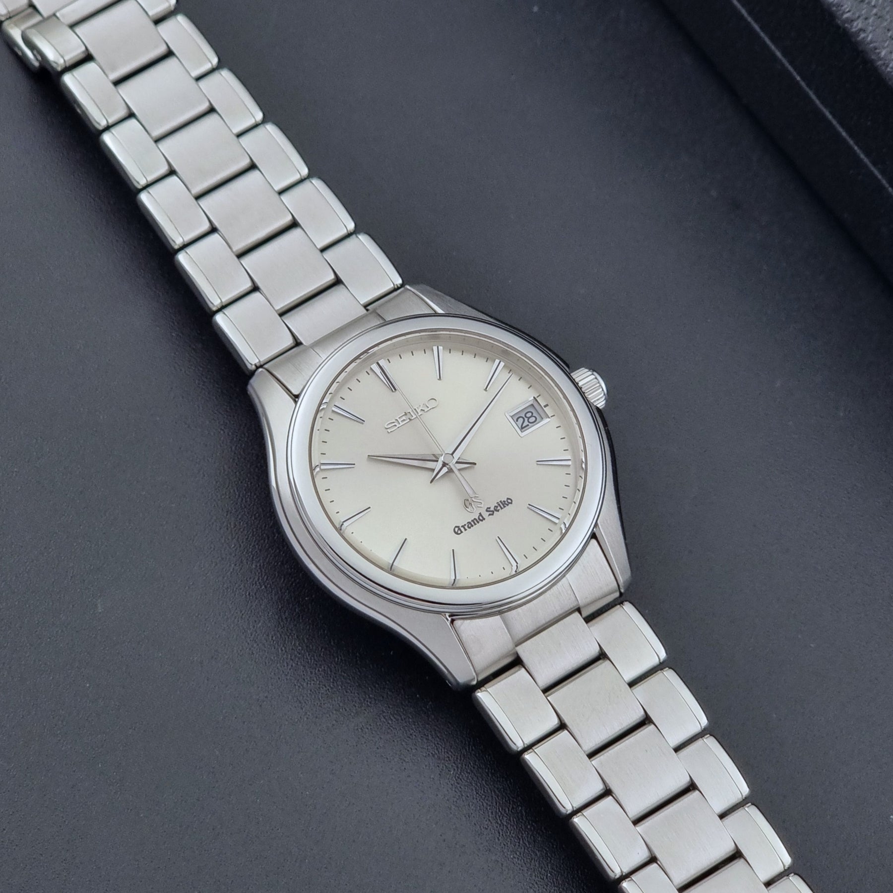 Grand Seiko SBGX005 quartz watch 9F62-0A10 with a detailed face on a dark textured surface dial
