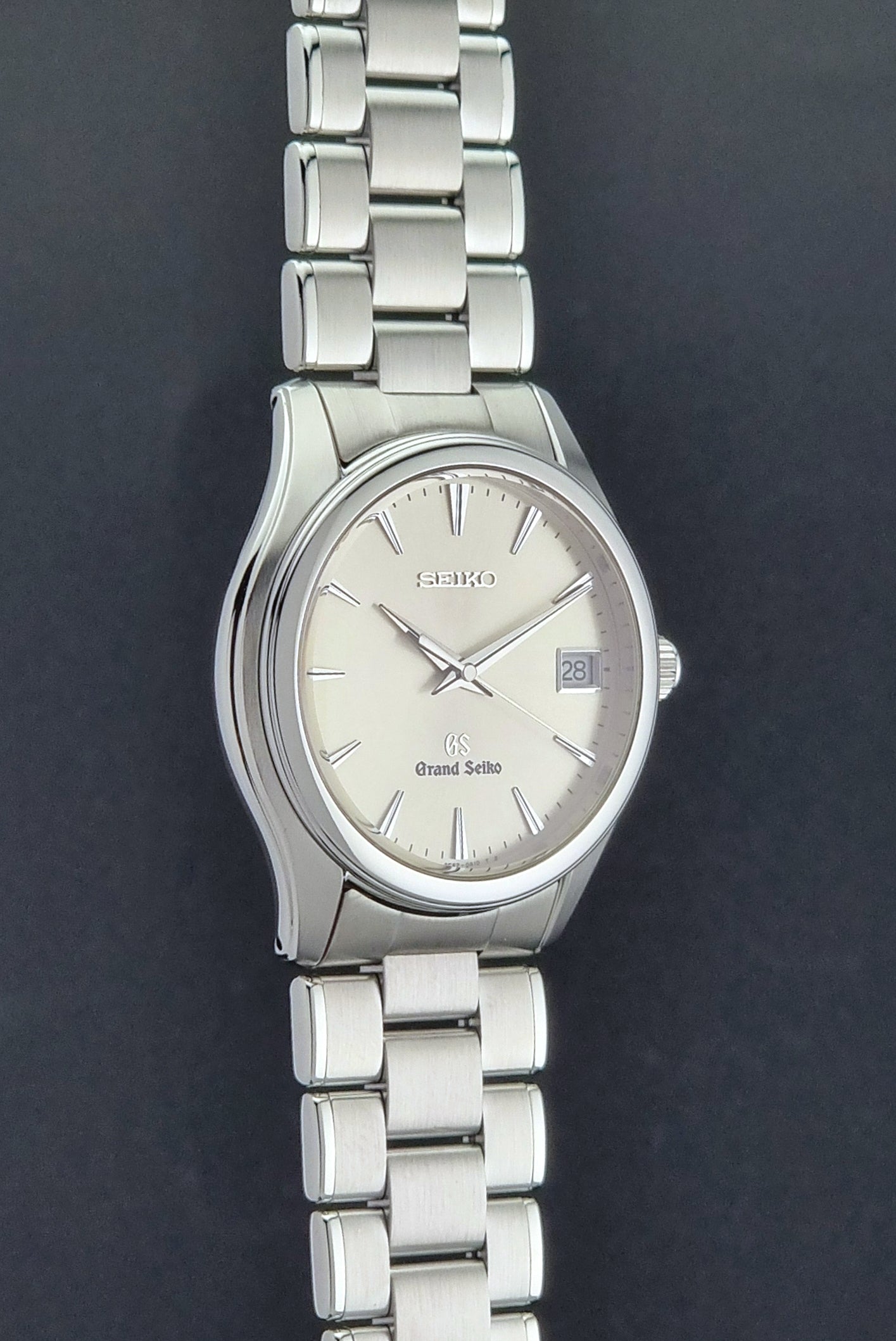 Grand Seiko SBGX005 quartz watch 9F62-0A10 with a detailed face on a dark textured surface side profile view