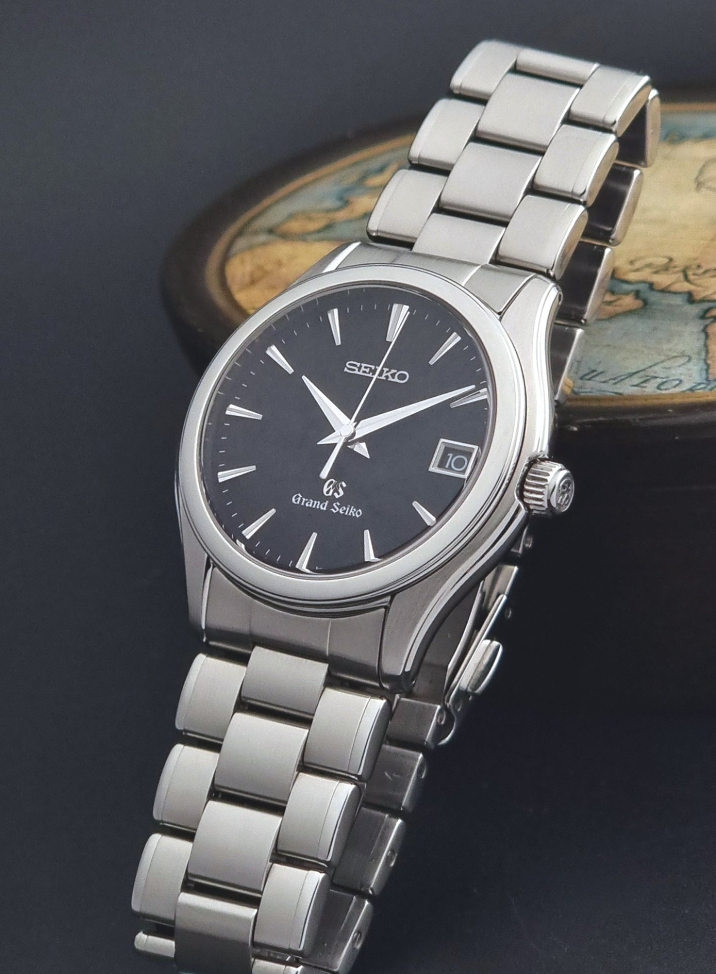 Grand Seiko quartz SBGX041 watch with black dial on a dark background crown view