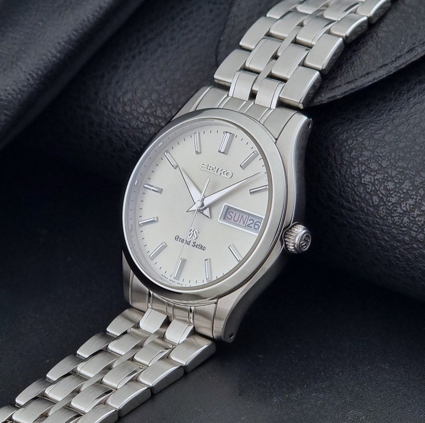 Vintage Grand Seiko SBGT005 quartz watch 9F83-9A30 with bracelet on a dark background crown view
