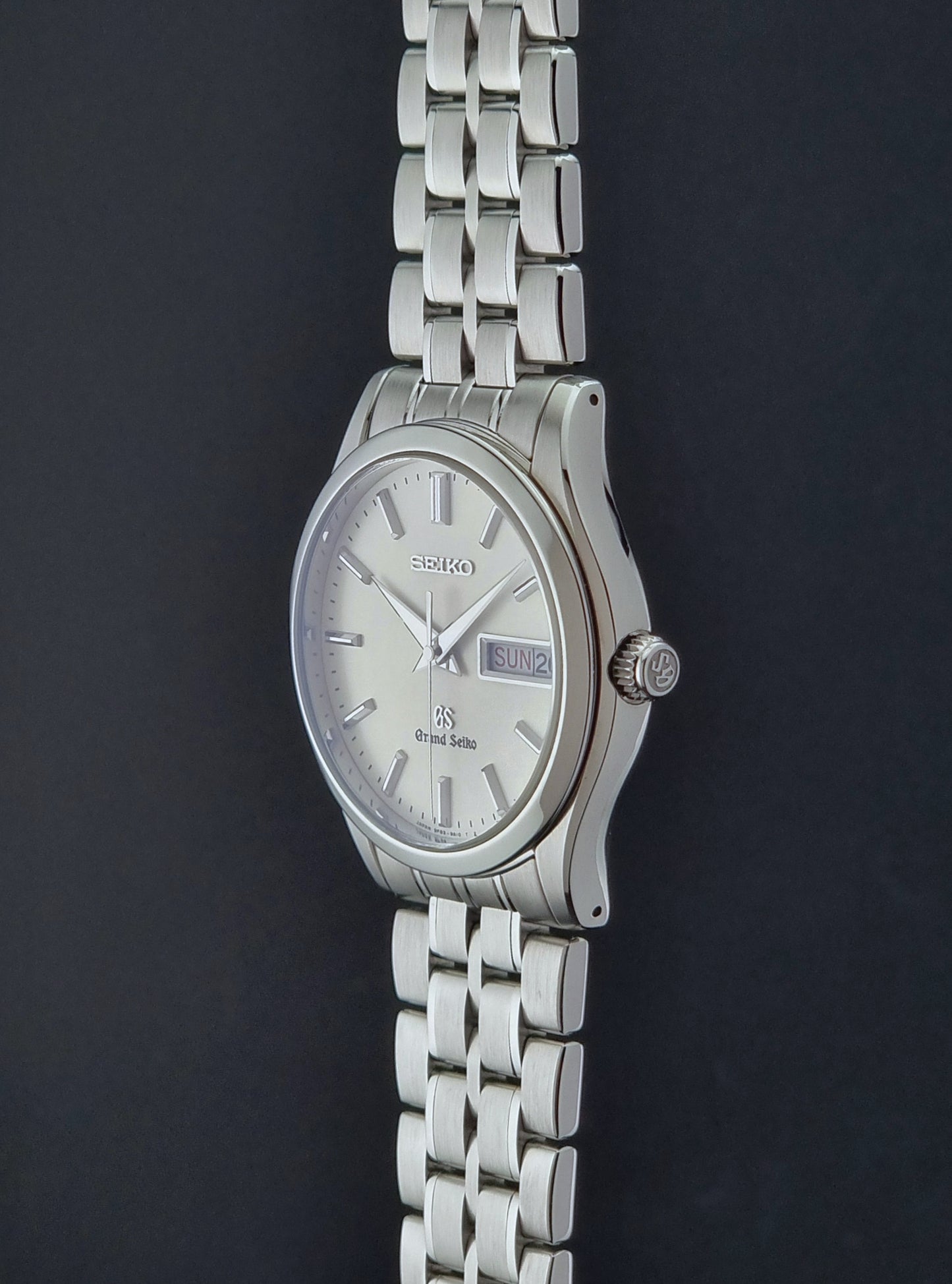 Vintage Grand Seiko SBGT005 quartz watch 9F83-9A30 with bracelet on a dark background crown profile view