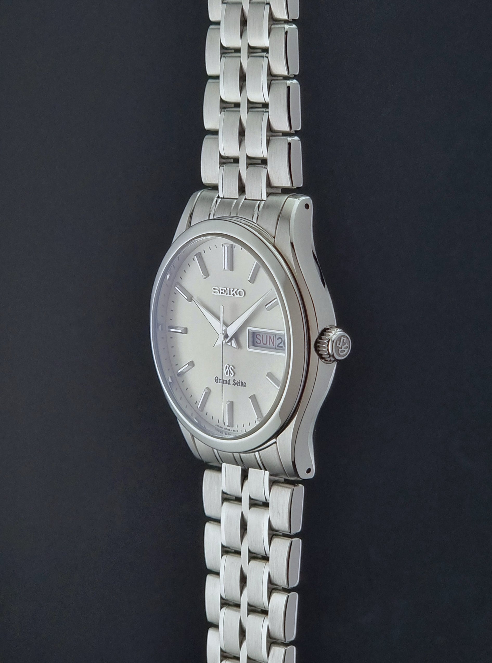 Vintage Grand Seiko SBGT005 quartz watch 9F83-9A30 with bracelet on a dark background crown profile view