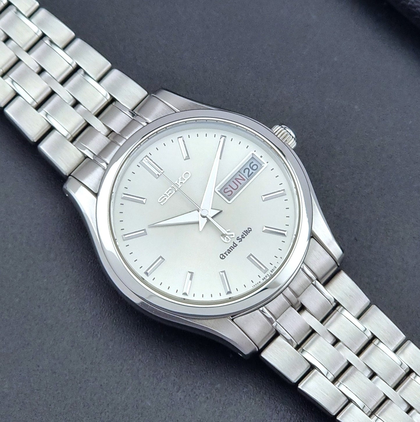 Vintage Grand Seiko SBGT005 quartz watch 9F83-9A30 with bracelet on a dark background close up dial view