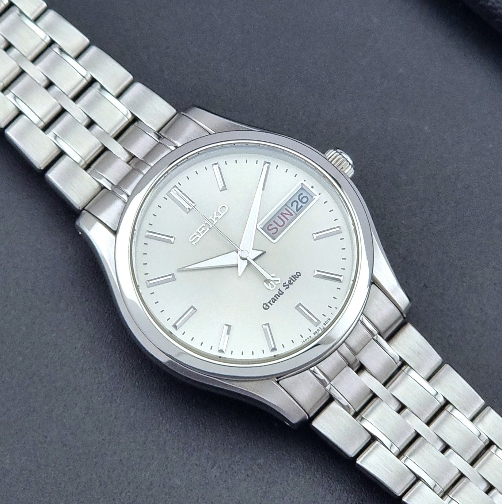 Vintage Grand Seiko SBGT005 quartz watch 9F83-9A30 with bracelet on a dark background close up dial view