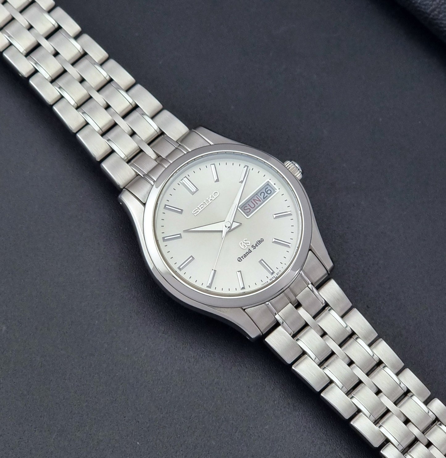 Vintage Grand Seiko SBGT005 quartz watch 9F83-9A30 with bracelet on a dark background dial