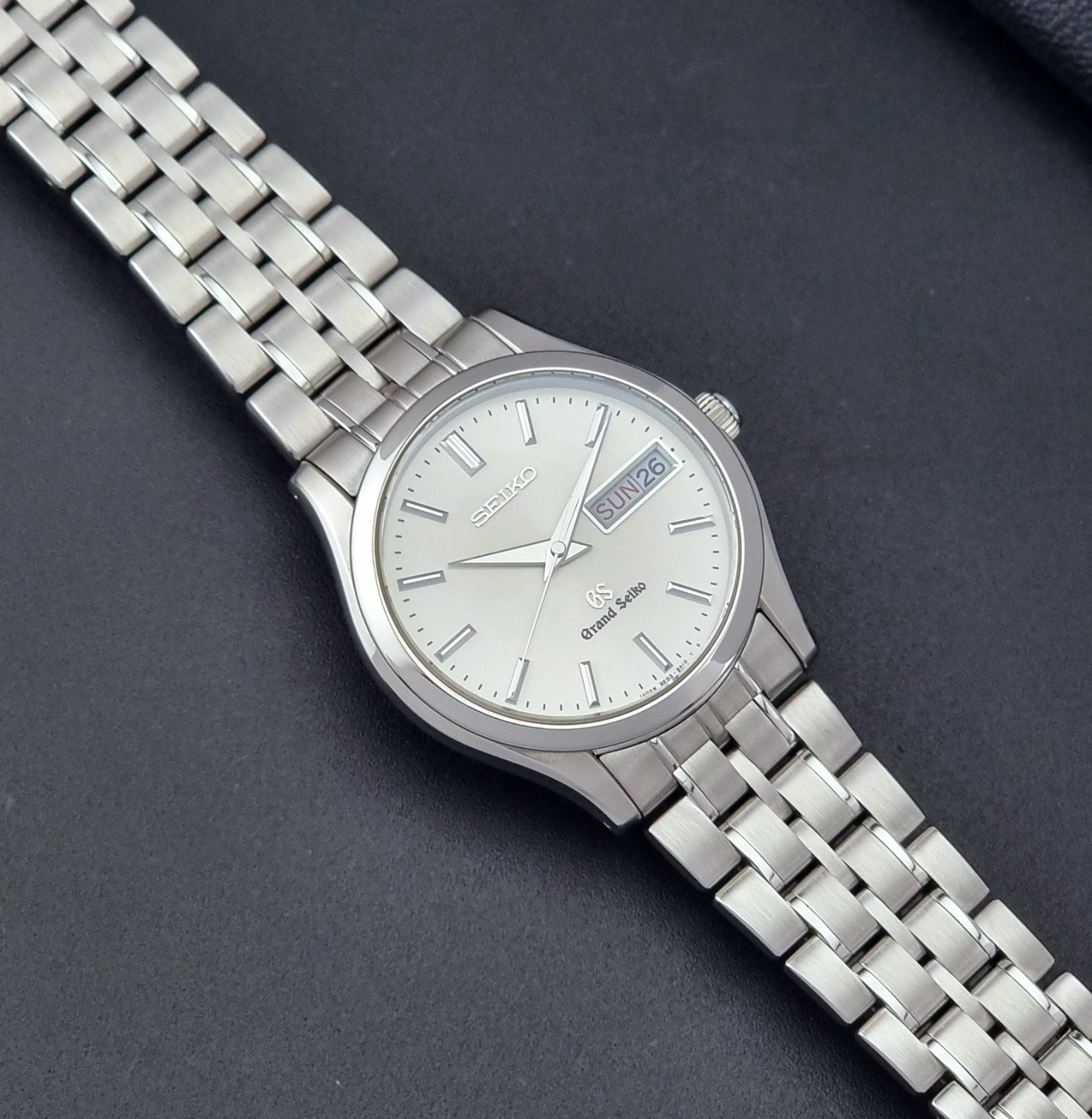 Vintage Grand Seiko SBGT005 quartz watch 9F83-9A30 with bracelet on a dark background dial