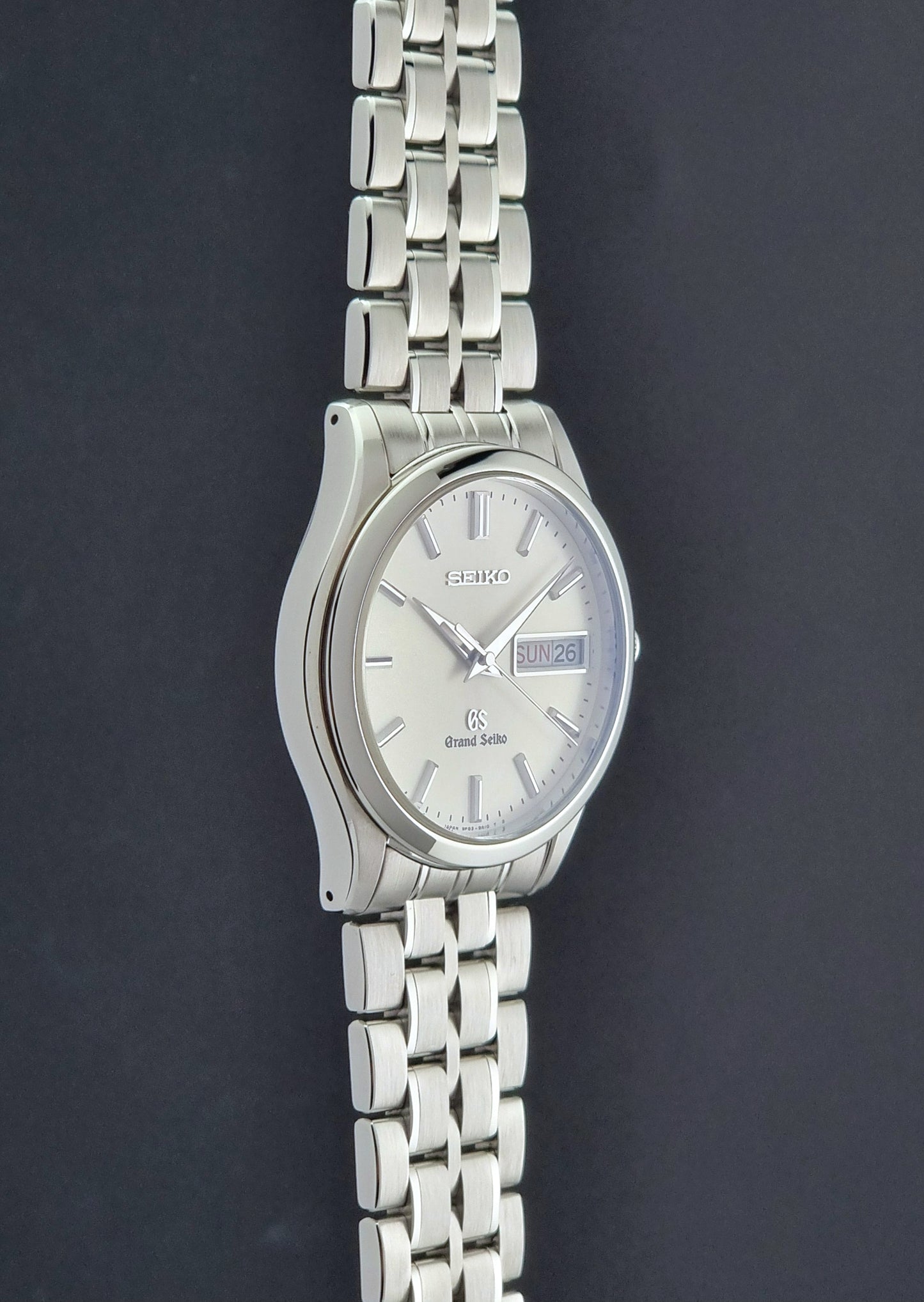 Vintage Grand Seiko SBGT005 quartz watch 9F83-9A30 with bracelet on a dark background side profile view