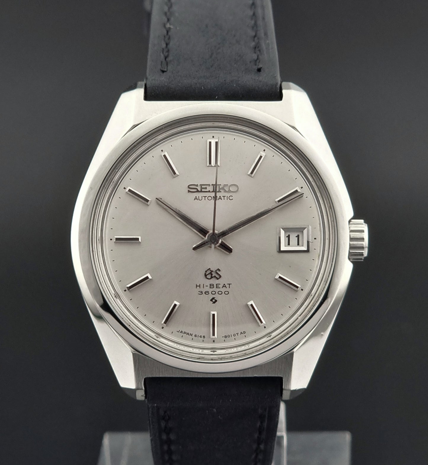 Seiko watch with black leather strap on a dark background