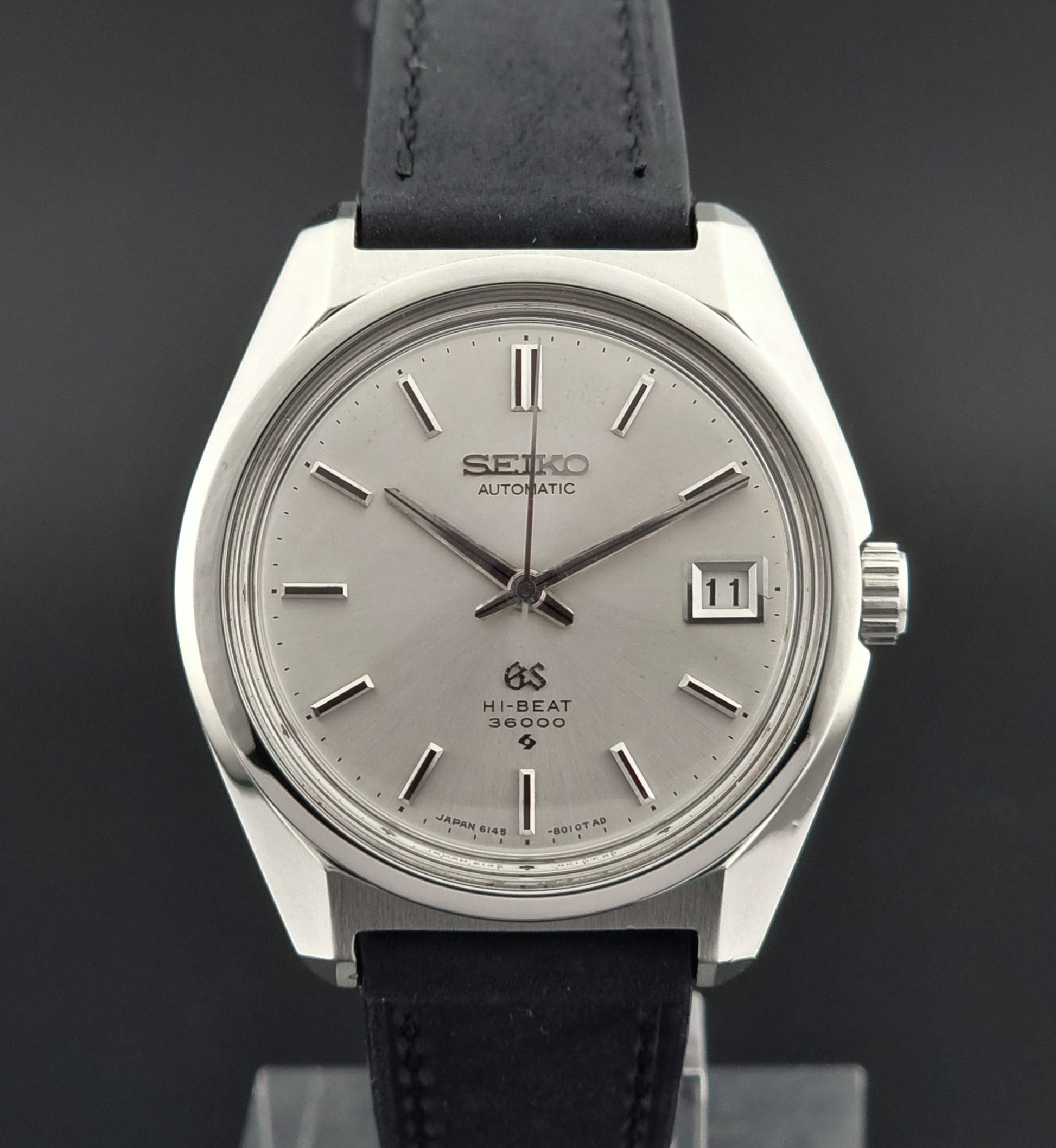 Seiko watch with black leather strap on a dark background