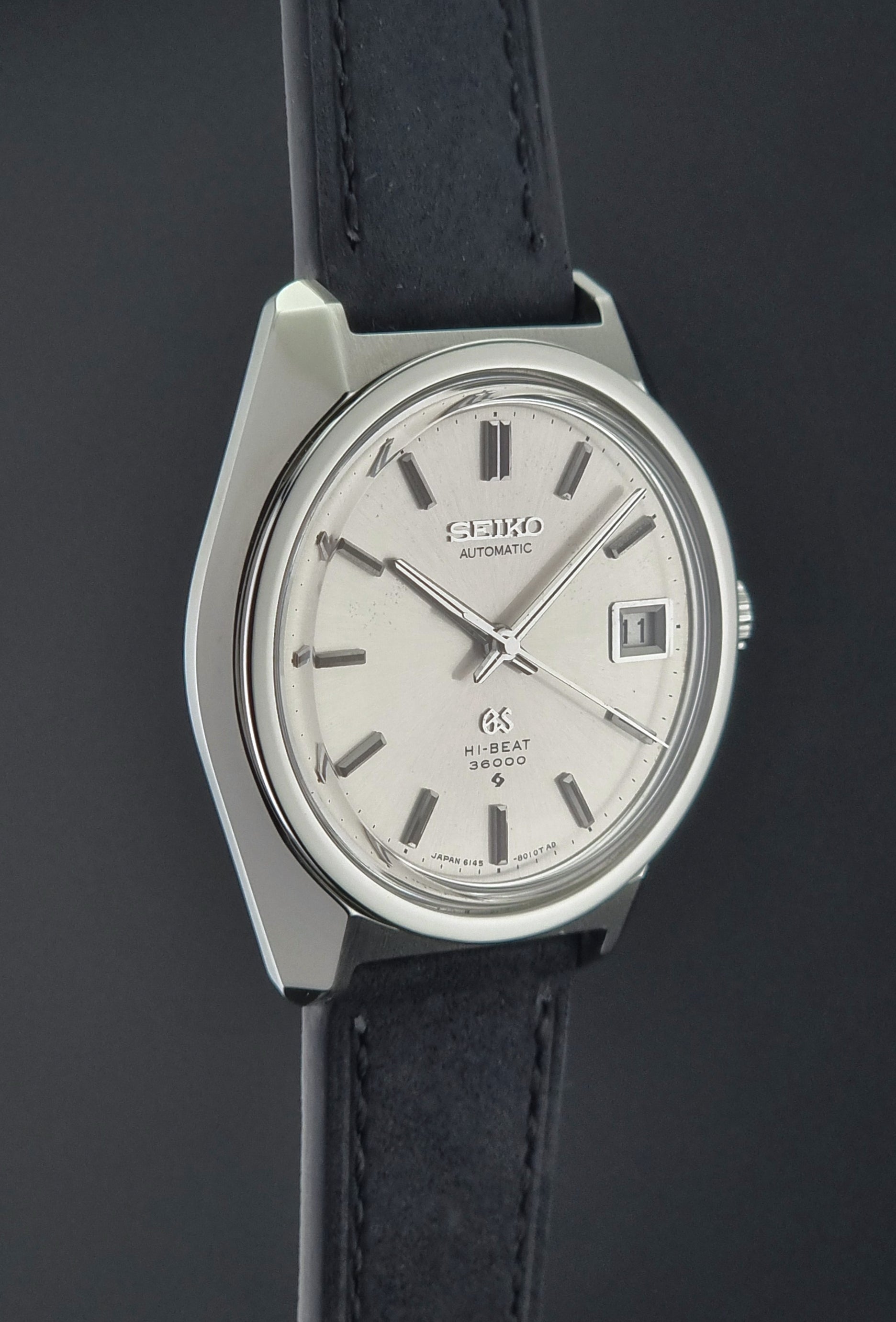 Seiko watch with black leather strap on a dark background