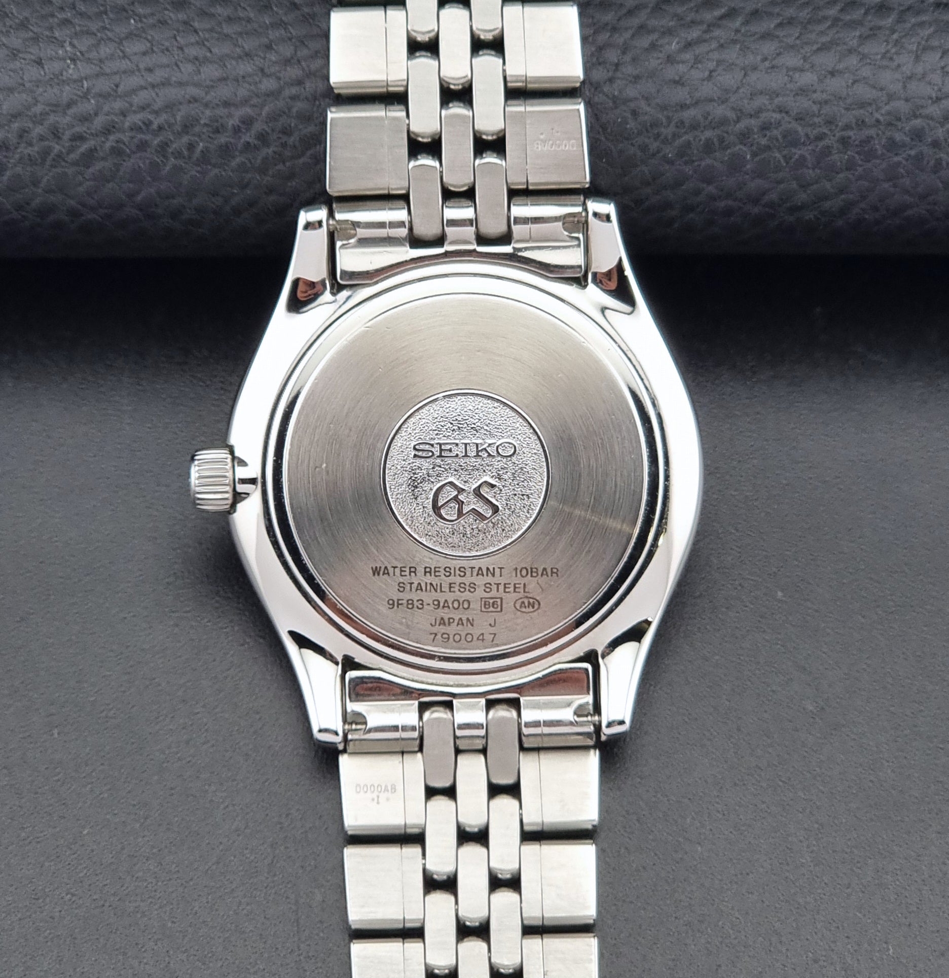 Vintage Grand Seiko watch SBGT001 9F83-9A00 with a white dial on a dark background caseback view