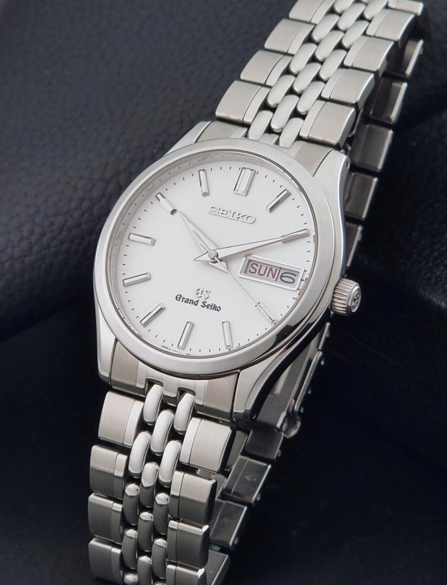 Vintage Grand Seiko watch SBGT001 9F83-9A00 with a white dial on a dark background crown view