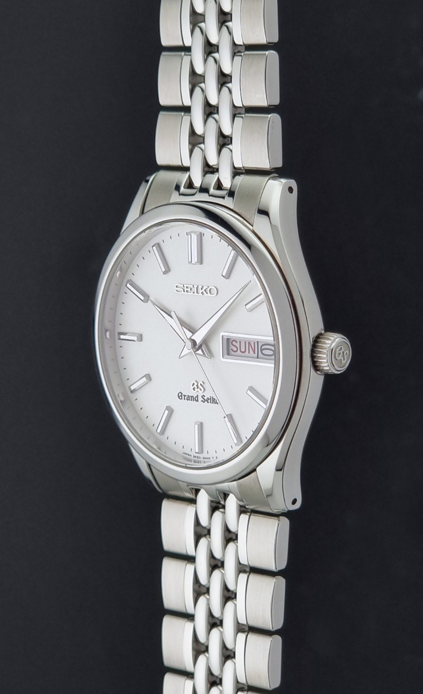 Vintage Grand Seiko watch SBGT001 9F83-9A00 with a white dial on a dark background crown profile view
