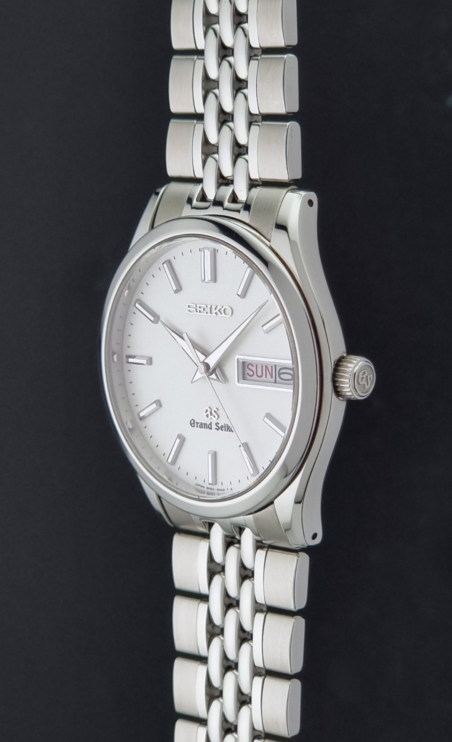 Vintage Grand Seiko watch SBGT001 9F83-9A00 with a white dial on a dark background crown profile view