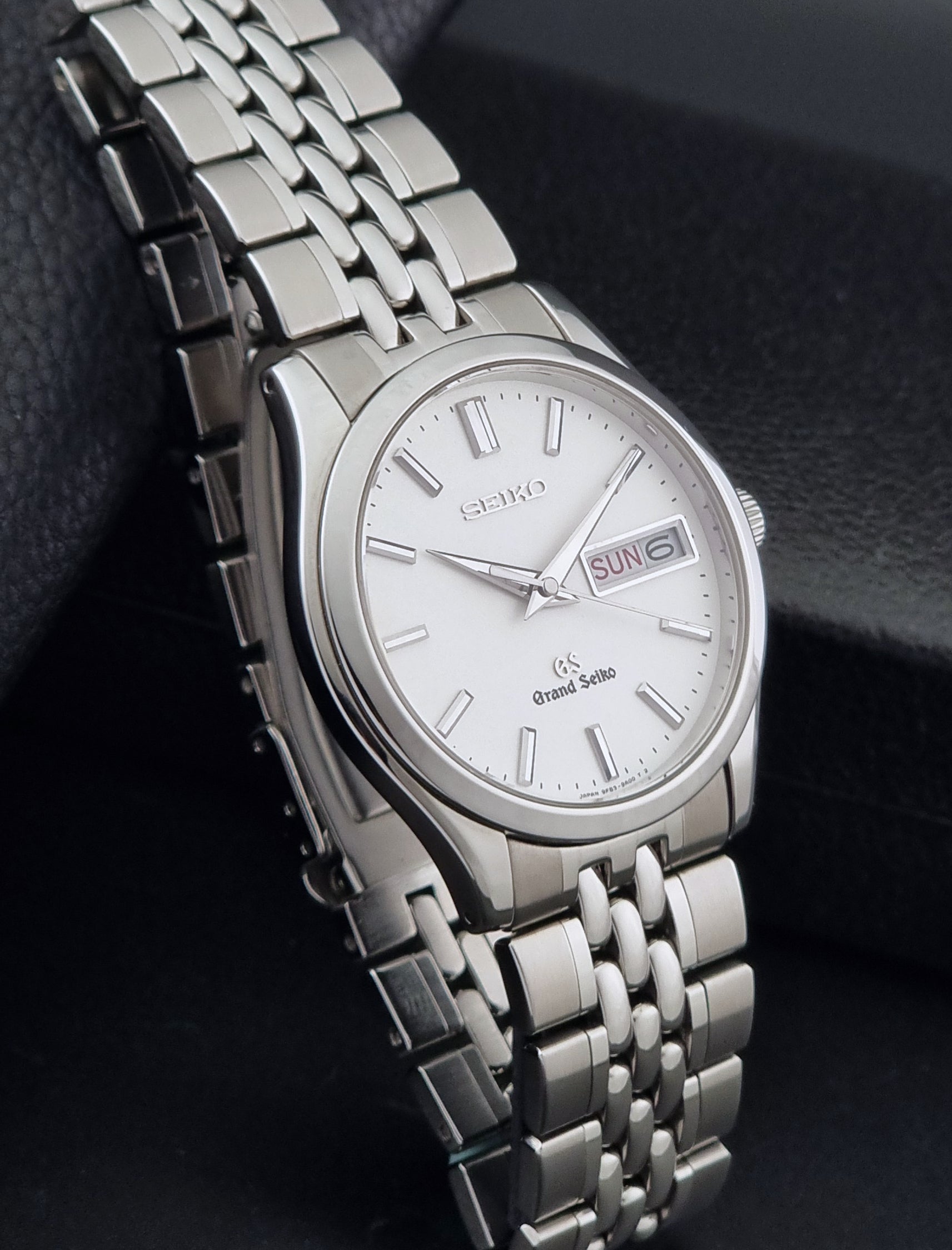 Vintage Grand Seiko watch SBGT001 9F83-9A00 with a white dial on a dark background side view