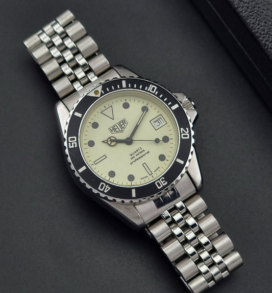 Vintage Heuer watch Professional Quartz 200 meters 980.113 on a textured black surface dial view