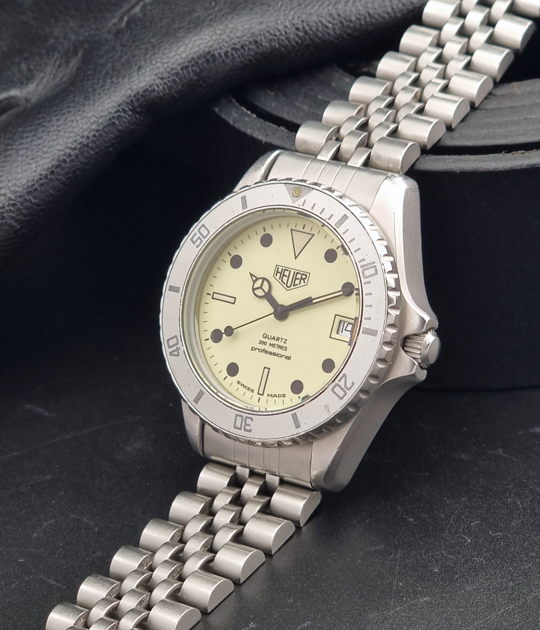 Vintage Heuer Wristwatch Professional Quartz Night Diver 982.113 with a pewter colours pvd coated case on a dark background crown view