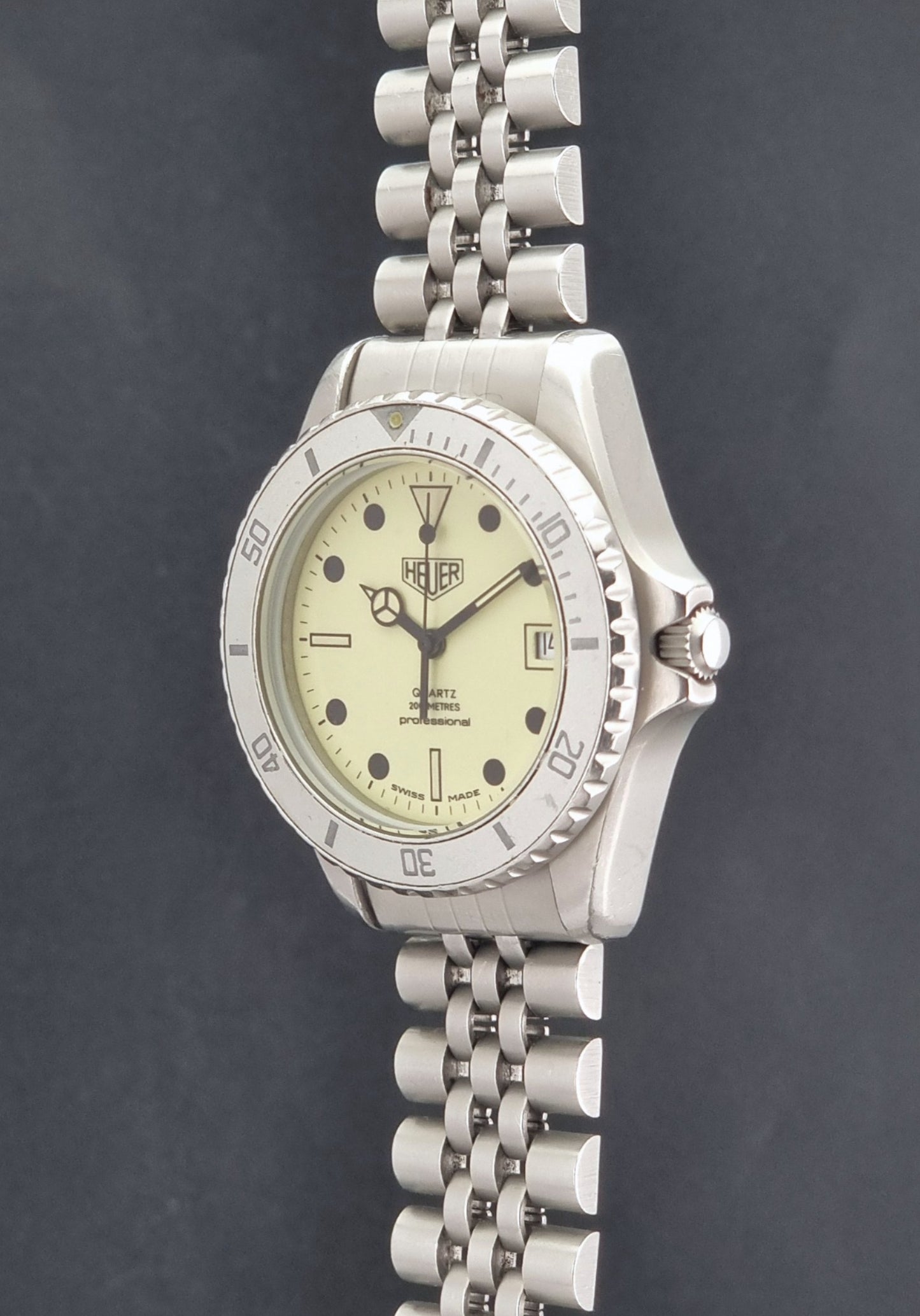 Vintage Heuer Wristwatch Professional Quartz Night Diver 982.113 with a pewter colours pvd coated case on a dark background crown profile view
