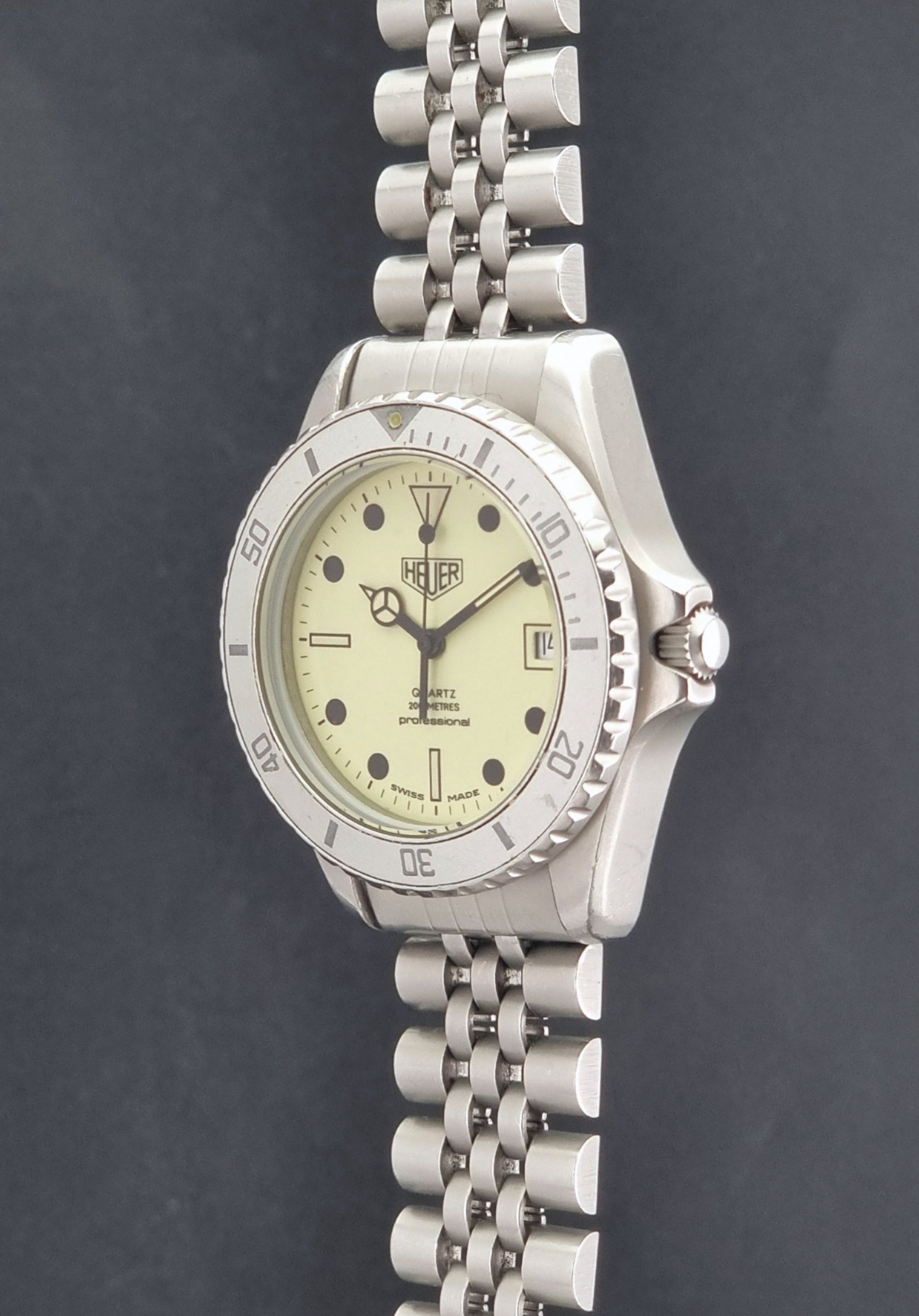 Vintage Heuer Wristwatch Professional Quartz Night Diver 982.113 with a pewter colours pvd coated case on a dark background crown profile view