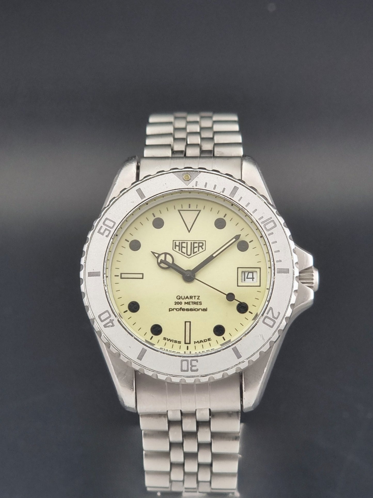 Vintage Heuer Wristwatch Professional Quartz Night Diver 982.113 with a pewter colours pvd coated case on a dark background close dial view
