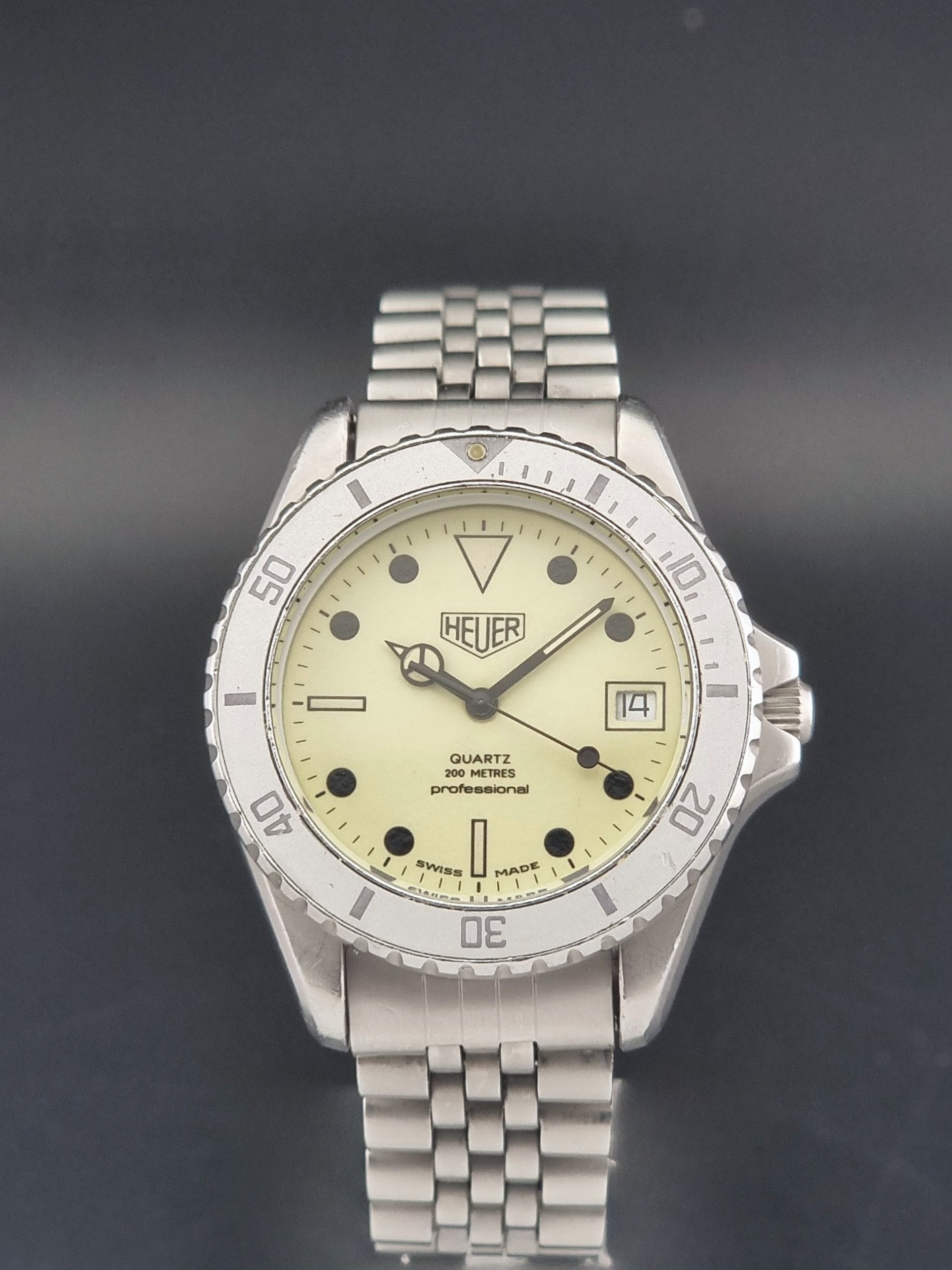 Vintage Heuer Wristwatch Professional Quartz Night Diver 982.113 with a pewter colours pvd coated case on a dark background close dial view