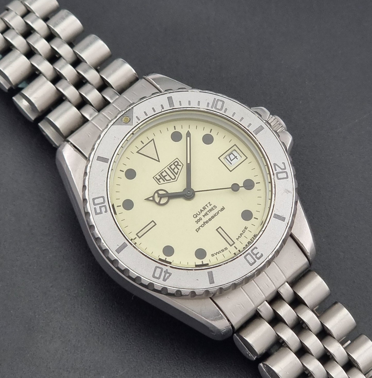 Vintage Heuer Wristwatch Professional Quartz Night Diver 982.113 with a pewter colours pvd coated case on a dark background close up dial view