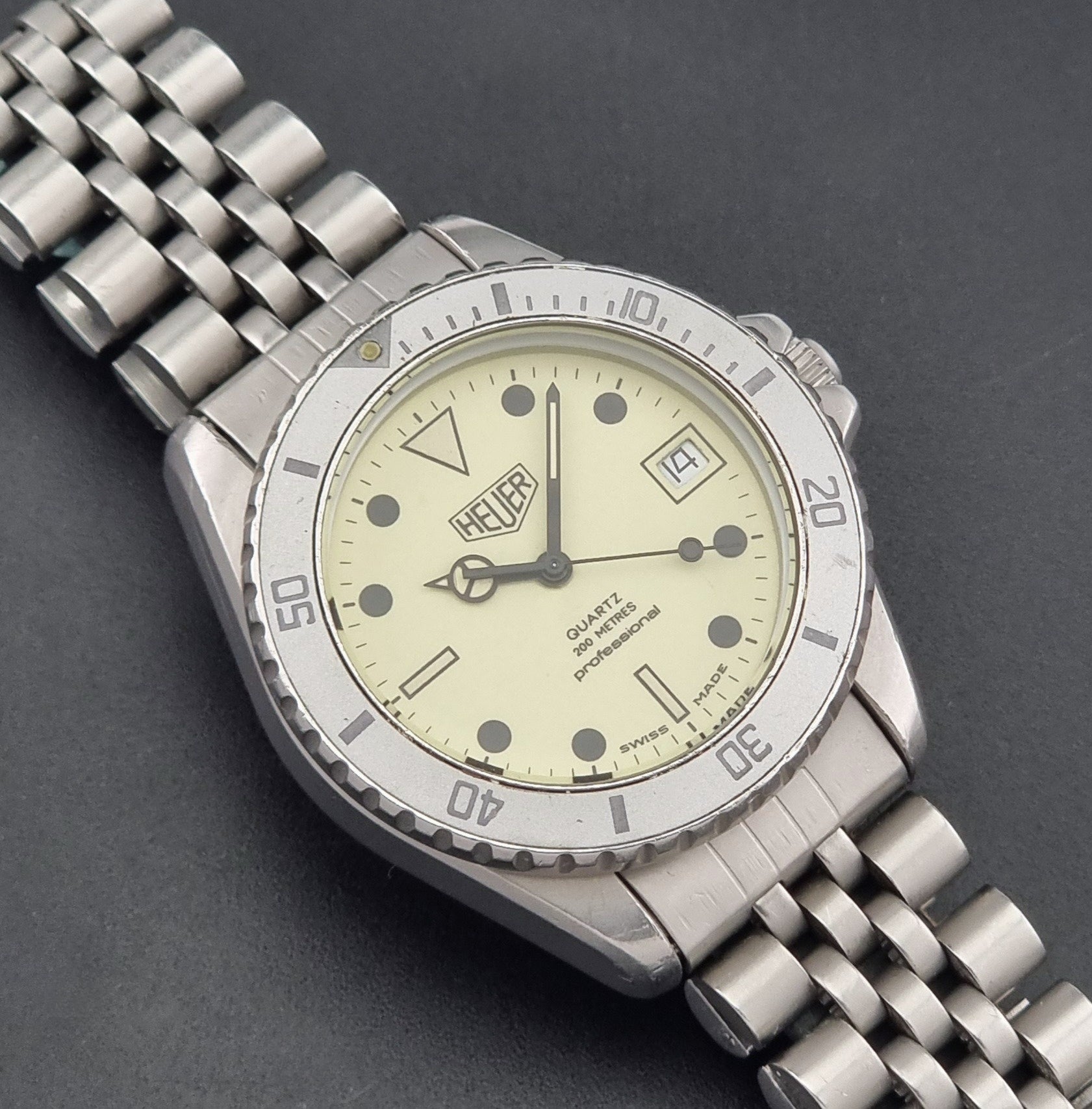 Vintage Heuer Wristwatch Professional Quartz Night Diver 982.113 with a pewter colours pvd coated case on a dark background close up dial view