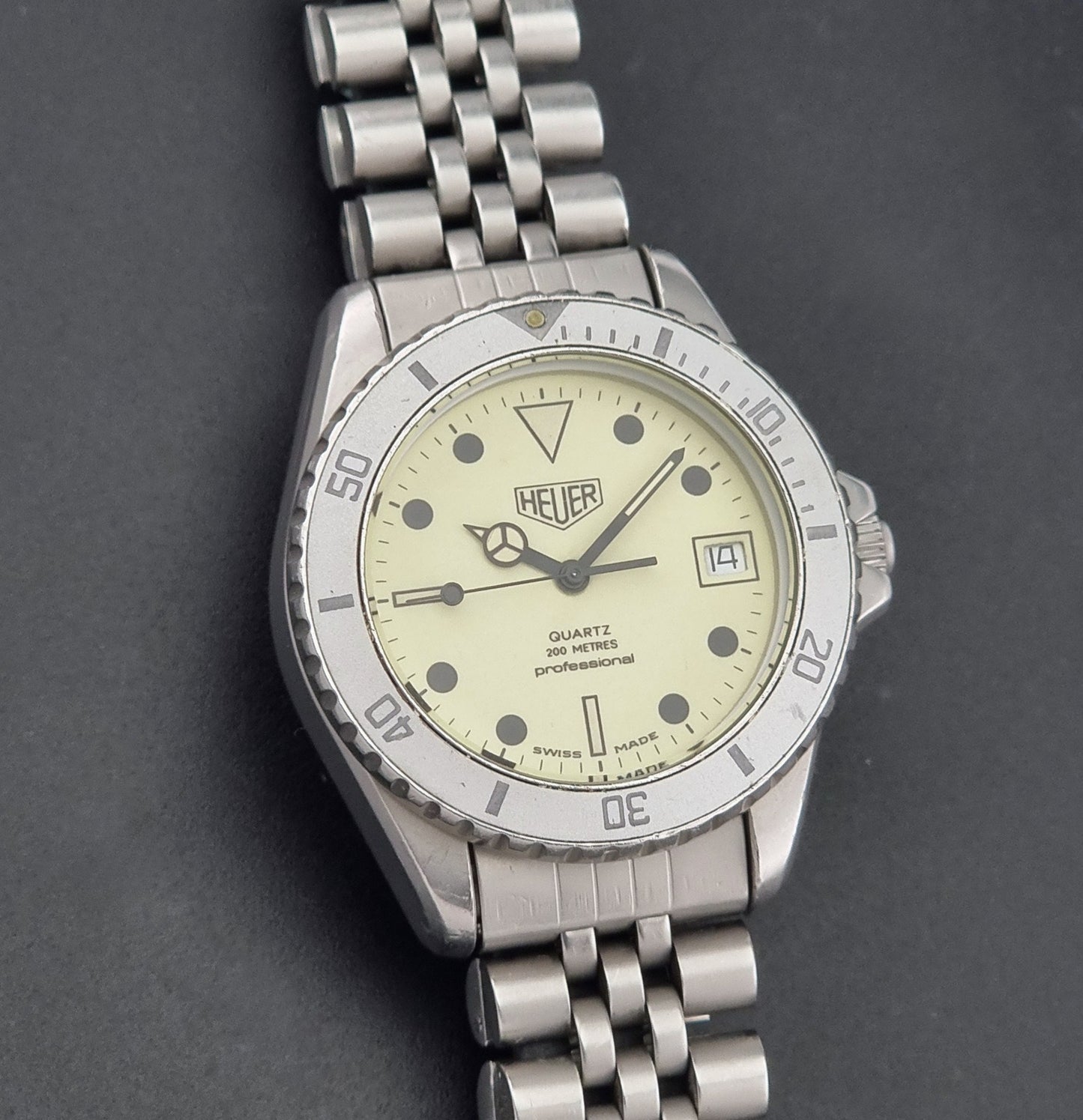 Vintage Heuer Wristwatch Professional Quartz Night Diver 982.113 with a pewter colours pvd coated case on a dark background front view