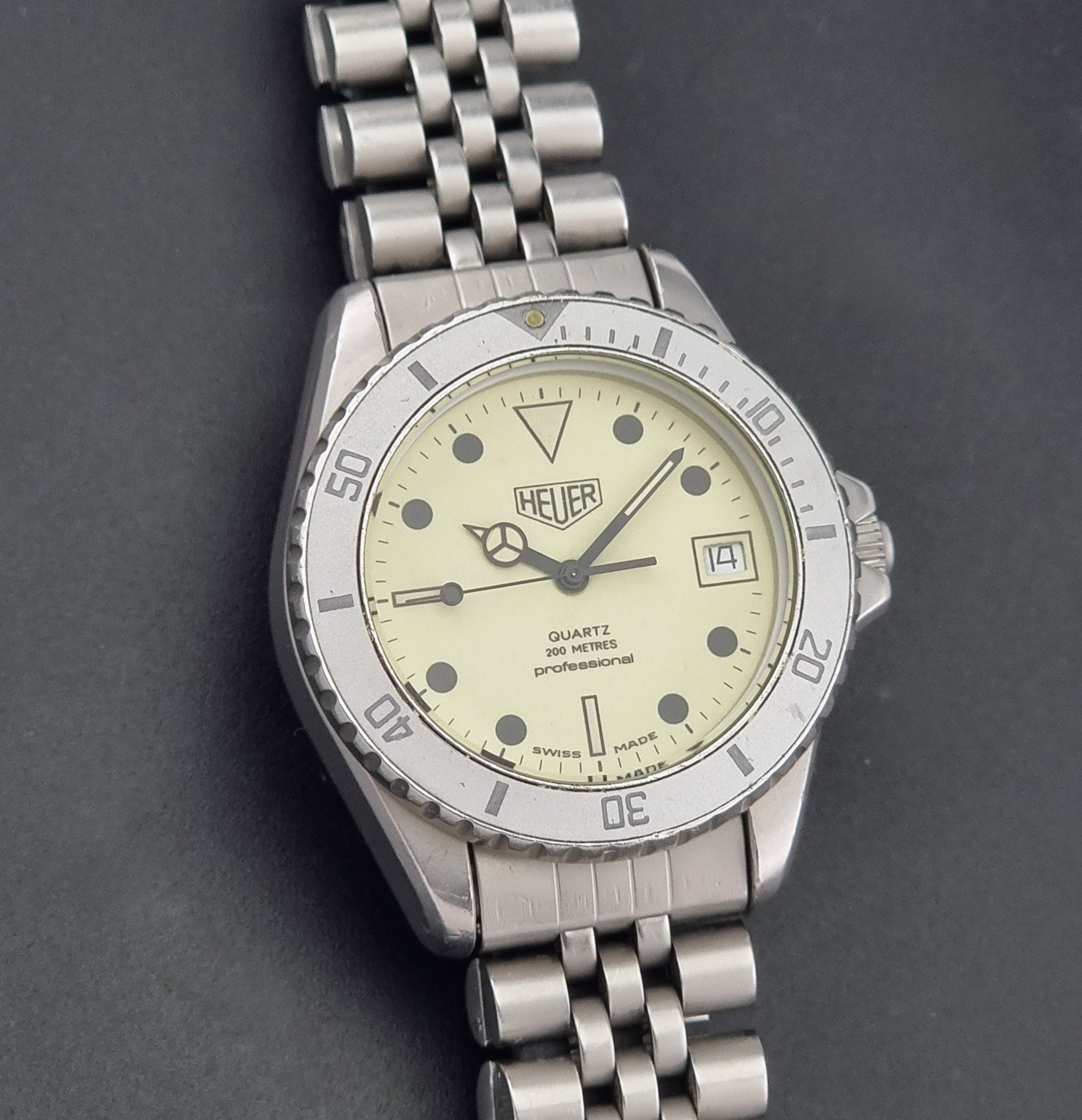 Vintage Heuer Wristwatch Professional Quartz Night Diver 982.113 with a pewter colours pvd coated case on a dark background front view