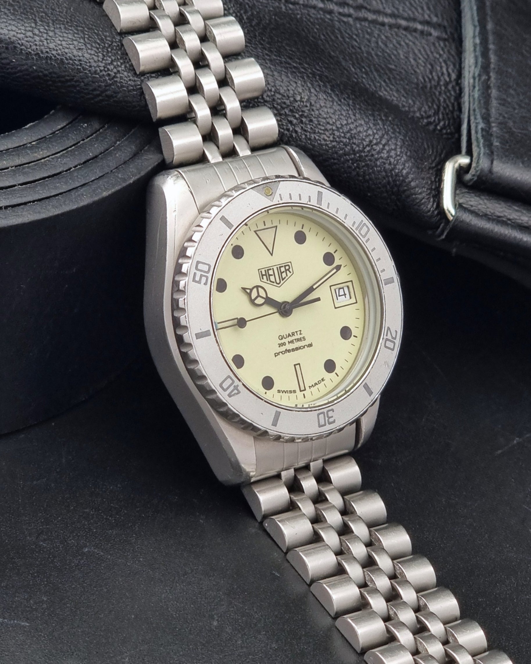 Vintage Heuer Wristwatch Professional Quartz Night Diver 982.113 with a pewter colours pvd coated case on a dark background side view
