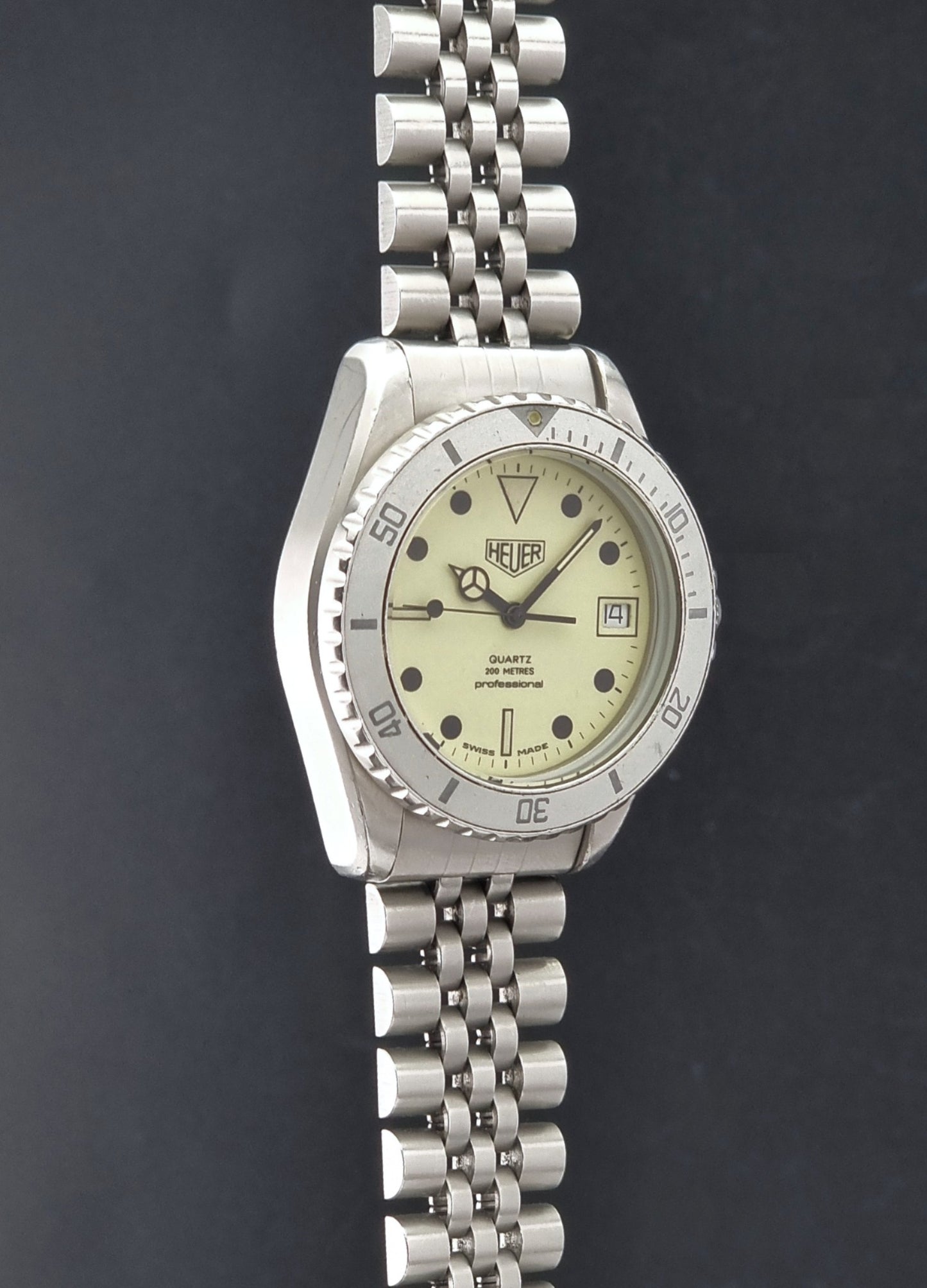Vintage Heuer Wristwatch Professional Quartz Night Diver 982.113 with a pewter colours pvd coated case on a dark background side profile view
