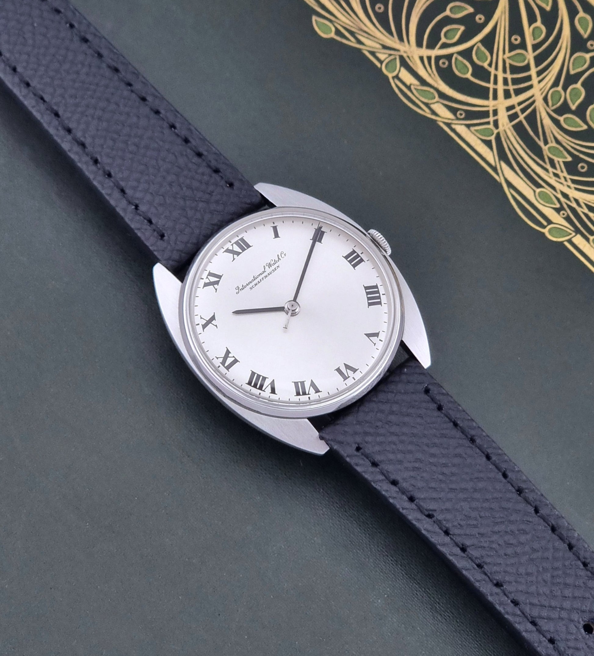 Vintage IWC R1419 Wristwatch with a black strap and silver dial on a dark background dial