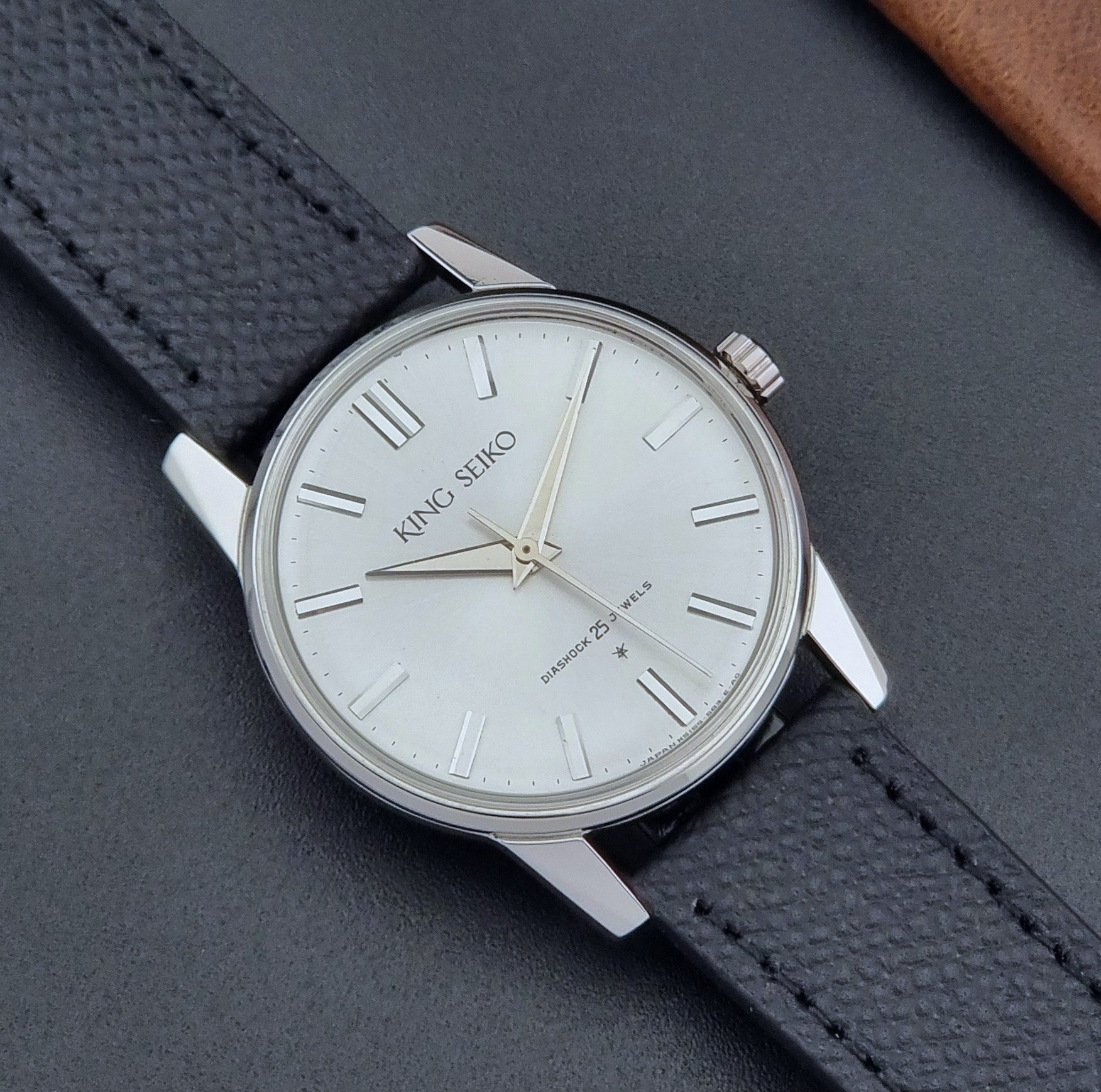 Vintage King Seiko Wristwatch 15034 with a black leather strap on a gray surface close up dial view