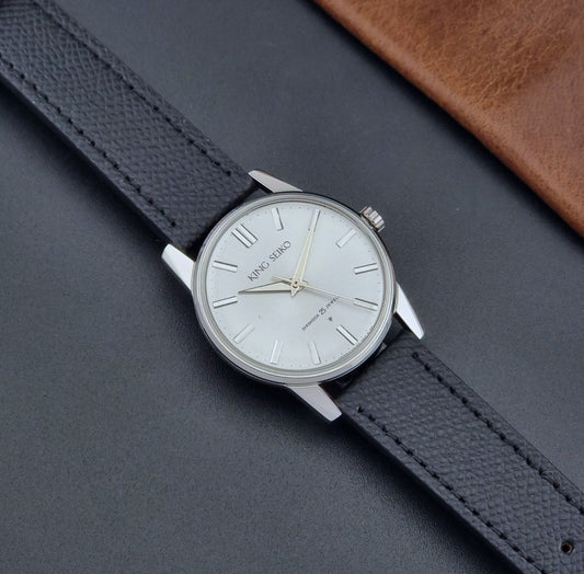 Vintage King Seiko Wristwatch 15034 with a black leather strap on a gray surface dial