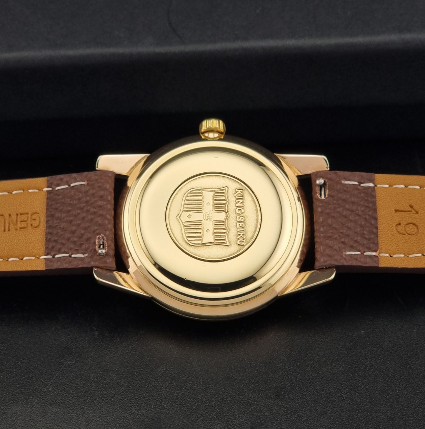 Vintage King Seiko Wristwatch 44-2000 with a gold filled case and brown leather strap on a dark background back view