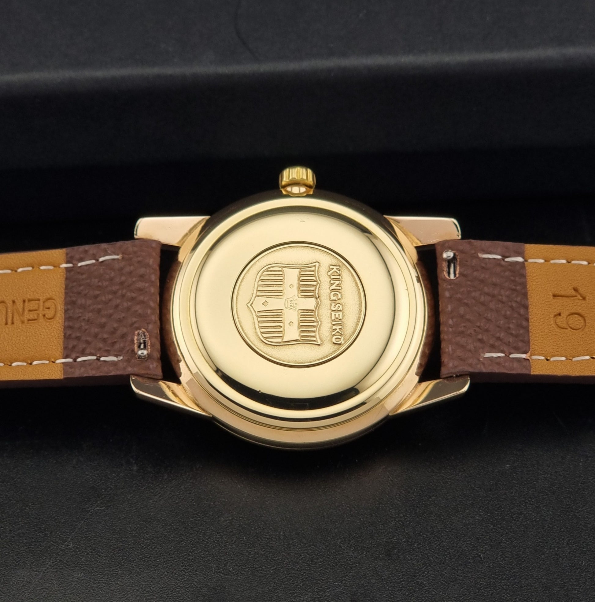 Vintage King Seiko Wristwatch 44-2000 with a gold filled case and brown leather strap on a dark background back view