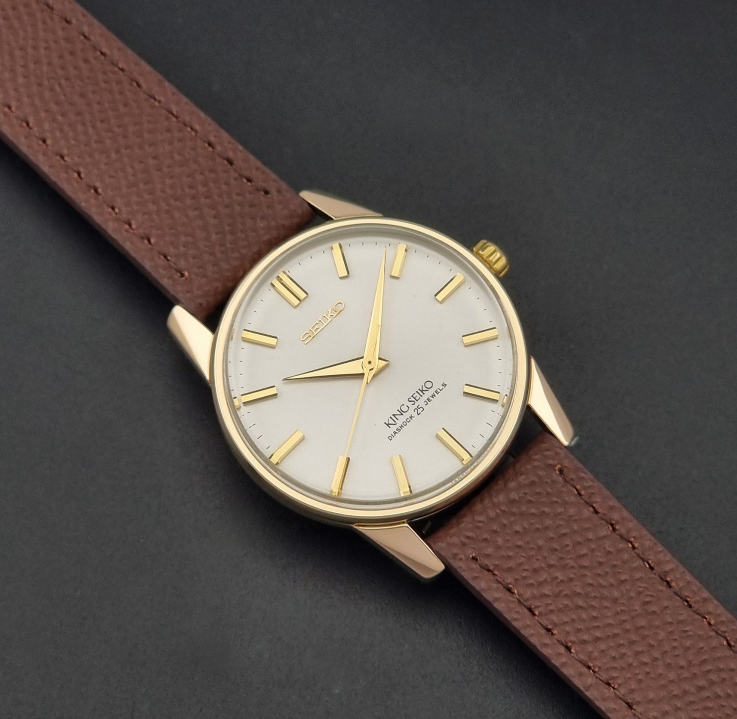 Vintage King Seiko Wristwatch 44-2000 with a gold filled case and brown leather strap on a dark background dial