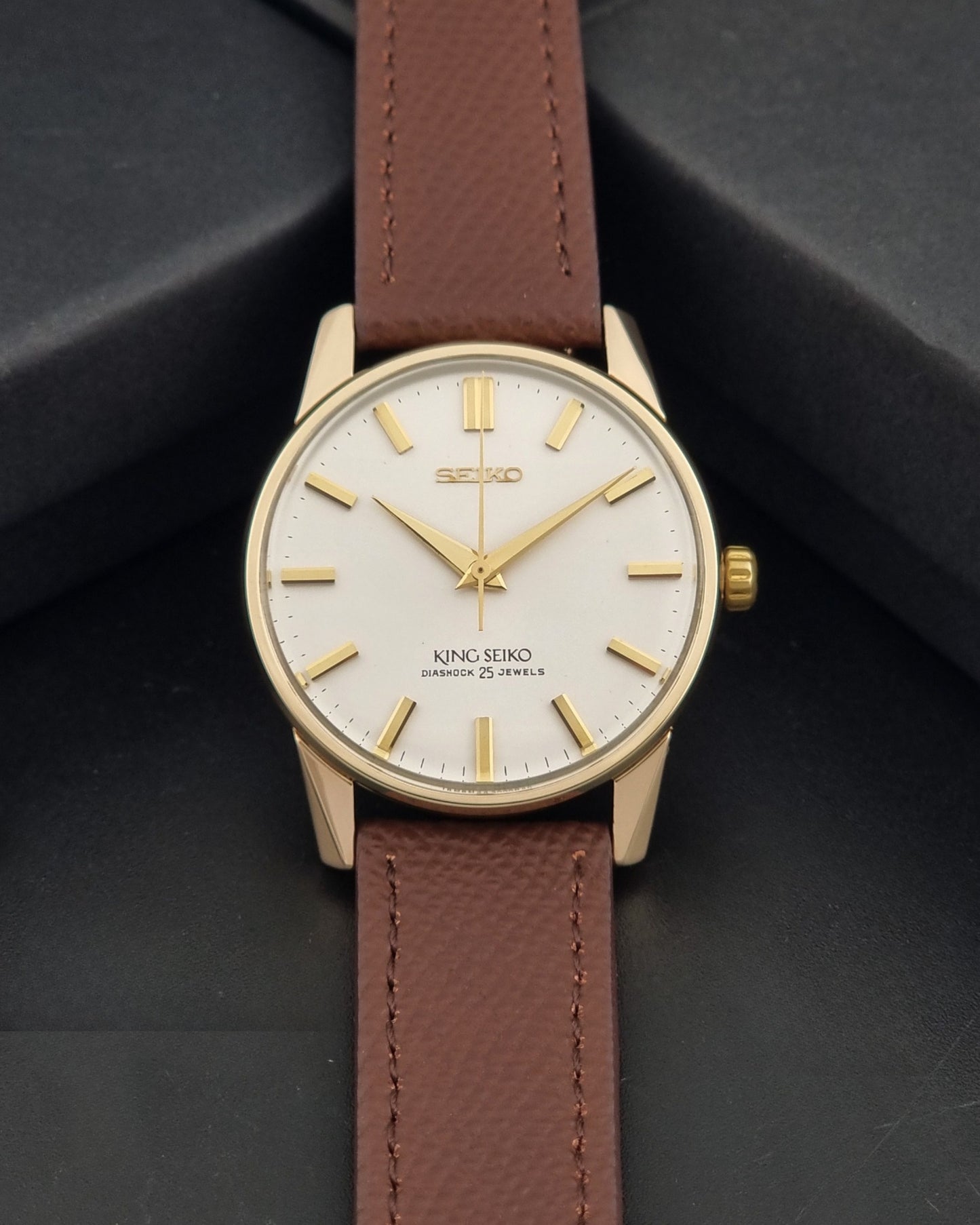 Vintage King Seiko Wristwatch 44-2000 with a gold filled case and brown leather strap on a dark background dial view