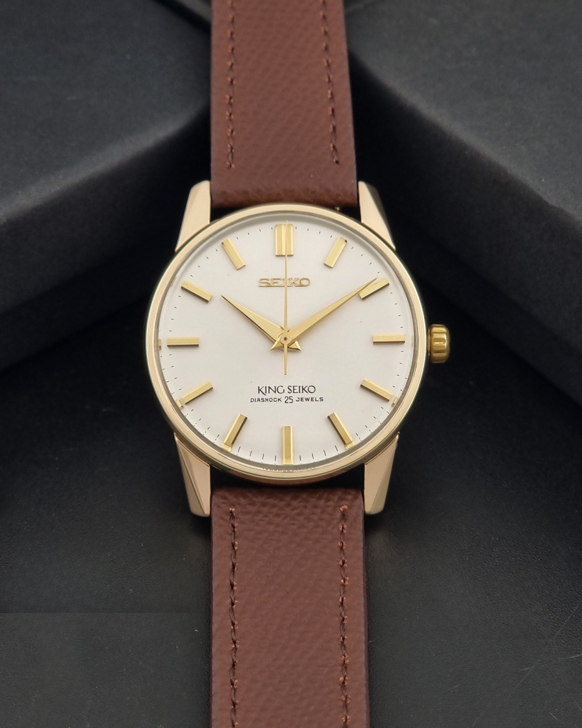 Vintage King Seiko Wristwatch 44-2000 with a gold filled case and brown leather strap on a dark background dial view
