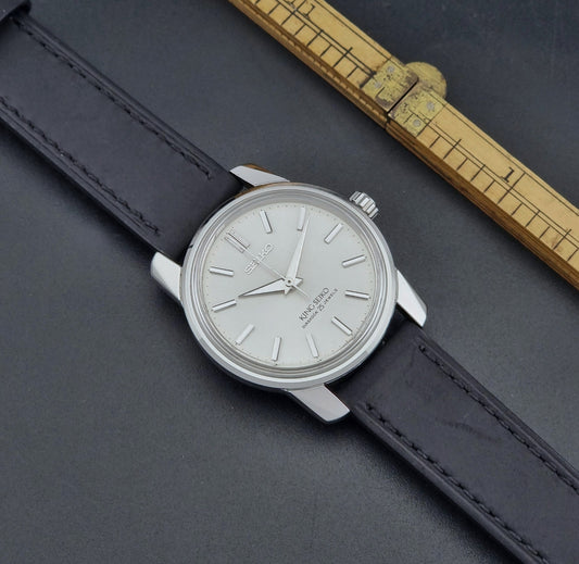 Vintage King Seiko Wristwatch 44-9990 with black leather strap and silver case on a dark surface dial