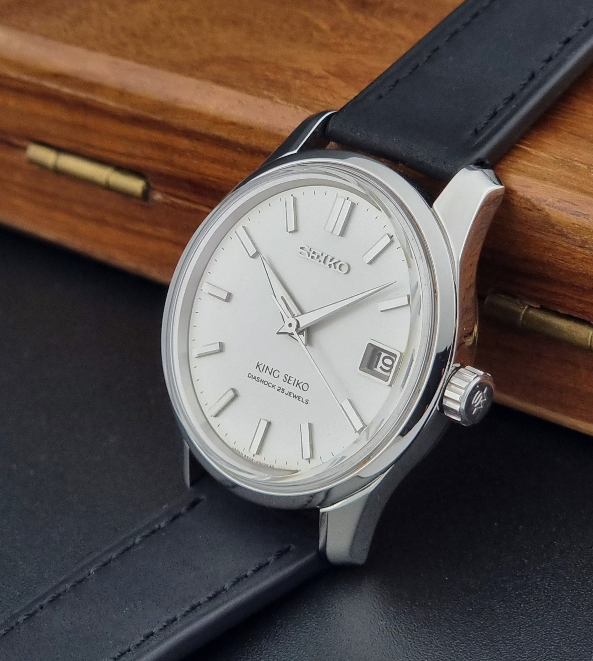 Vintage King Seiko 4402-8000  watch with black leather strap on a wooden surface
