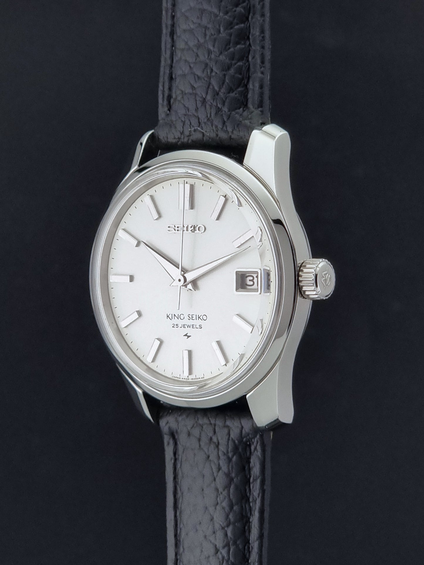 Vintage King Seiko 4402-8000 Wristwatch with a white dial on a dark background crown profile view