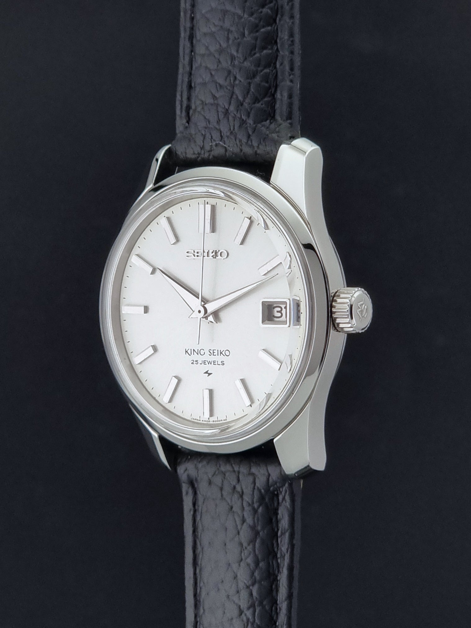 Vintage King Seiko 4402-8000 Wristwatch with a white dial on a dark background crown profile view