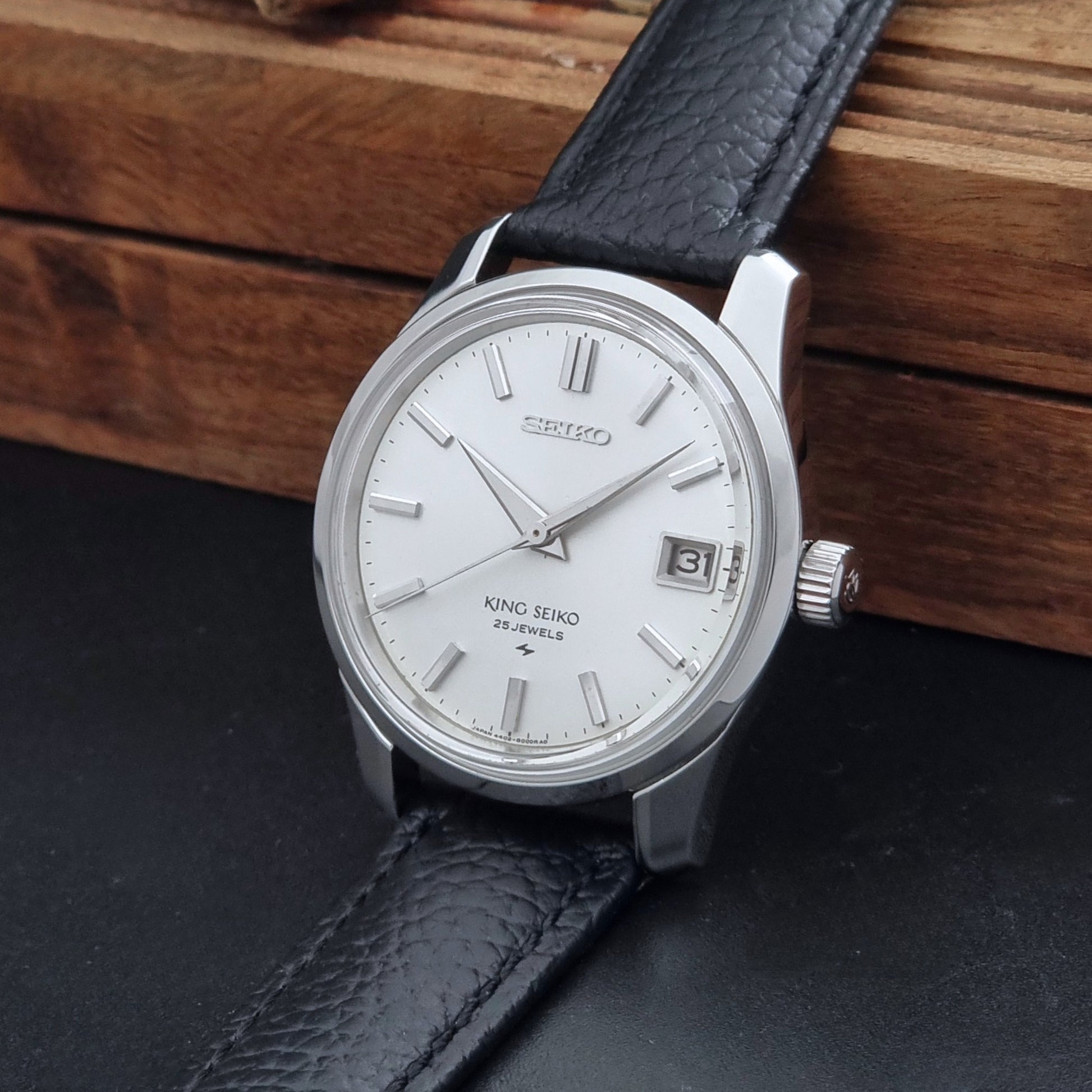 Vintage King Seiko 4402-8000 Wristwatch with a white dial on a dark background crown view