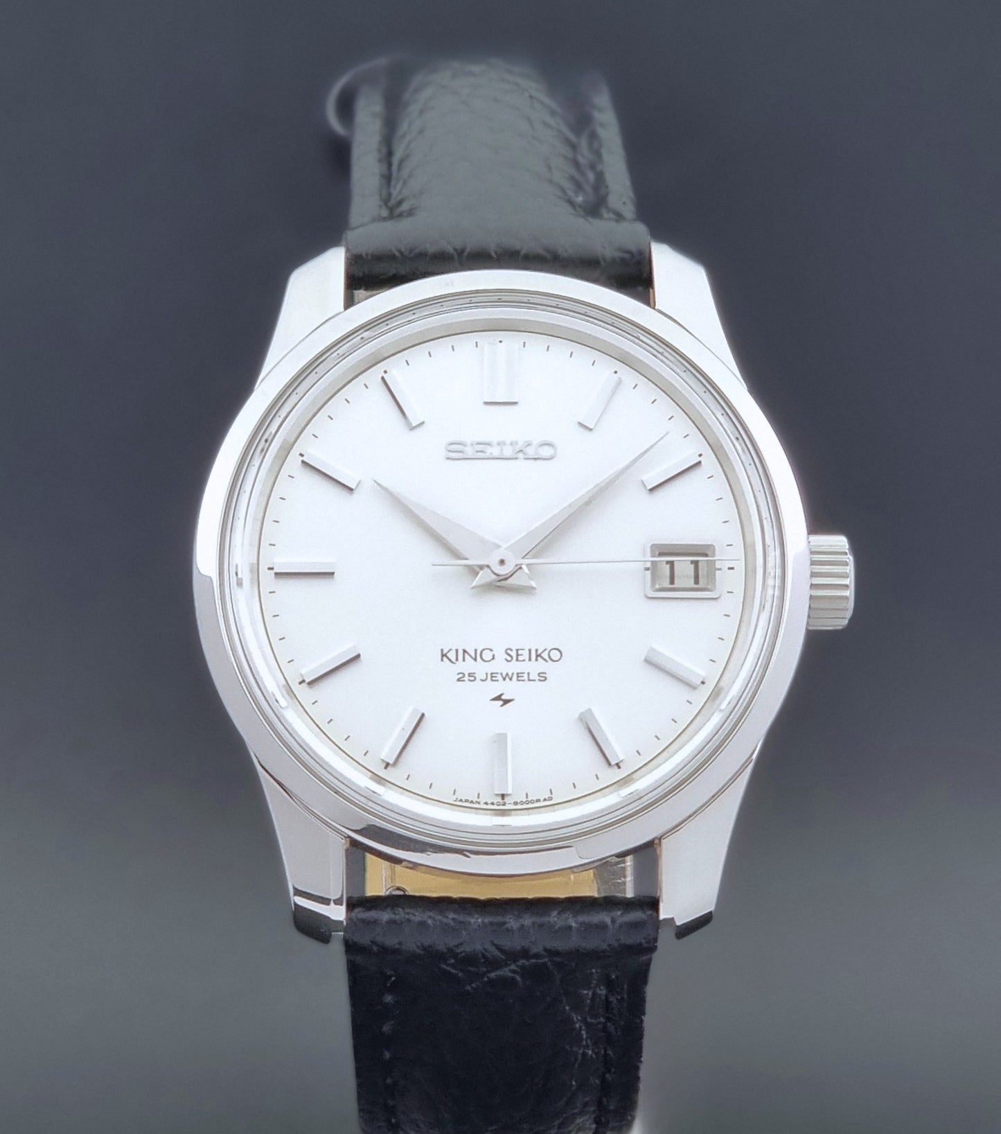 Vintage King Seiko Wristwatch 4402-8000 on a black leather strap on a dark background front