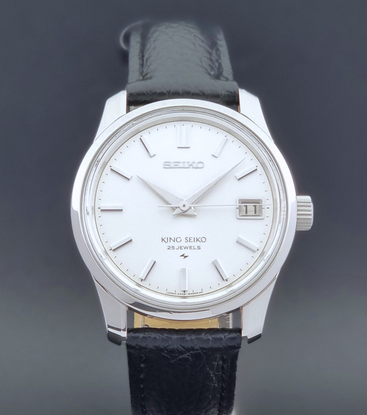 Vintage King Seiko Wristwatch 4402-8000 on a black leather strap on a dark background front